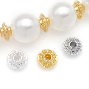Close-up detail of copper 18k gold plated UFO spacer beads and pearls for DIY jewelry making.