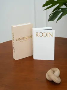 Vista dettagliata di libri finti decorativi in lino con stampa artistica in lamina d'oro.