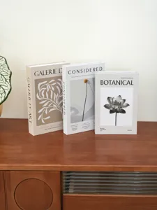 Detailed view of minimalist decorative faux books with botanical design for home decor.