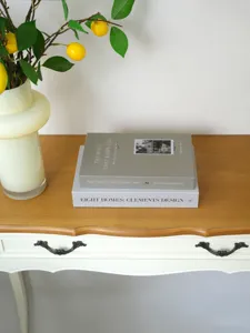 Detailed close-up of decorative fake books stacked neatly on a stylish wooden console table.