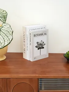 Decorative fake book set with botanical lotus illustration for modern home decor shelf styling.