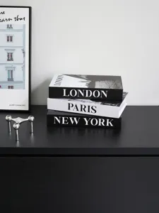 Decorative fake book set with London, Paris and New York prints for modern home decor detail.