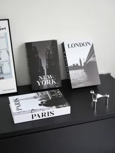 Detailed view of modern decorative fake books with New York, London and Paris designs on table.