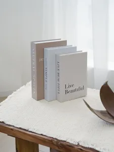 Detail view of modern faux decorative books set, elegant home shelf and coffee table decor.