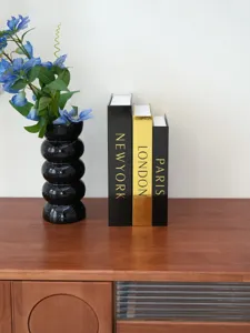 Decorative fake book storage box set with vase and artificial flowers for home desk decor.