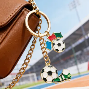 Detailfoto van metalen voetbalsleutelhanger met voetbal- en schoenbedels aan bruine tas.