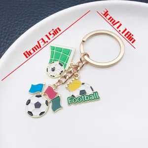 Detail view of the metal football keychain with crown and goal charms, measuring 8cm length.