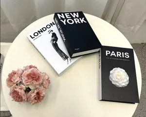 Detail view of decorative English coffee table books with floral prop on table, stylish home decor.
