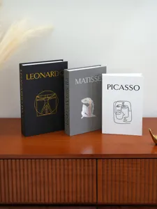 Close-up shot of decorative storage book boxes featuring classic artist designs and linen texture.