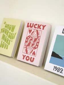Close-up detail of modern decorative fake books featuring stylish illustrations and typography.