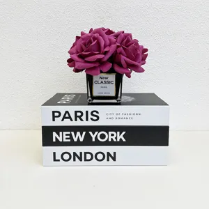Decorative fake books set with artificial roses flower arrangement for home modern decor.