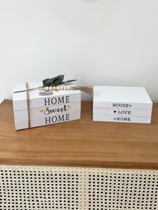 Close-up detail of decorative fake book storage boxes with rustic English text and twine.