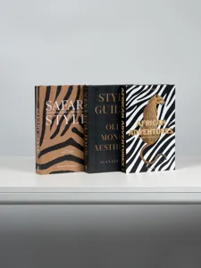 Close-up detail of decorative books set, elegant coffee table props on white surface.