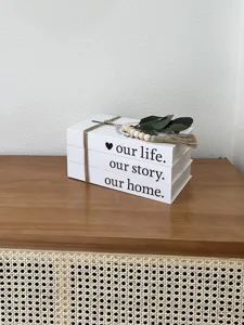 Rustic decorative storage book detail with wooden beads and green leaves on wooden cabinet.