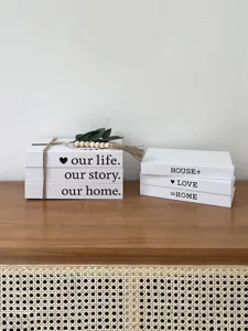 Close-up detail of decorative rustic faux book storage boxes with English text and beads.