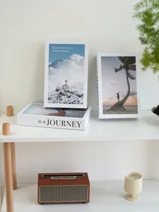 Detailed view of minimalist decorative book props with inspirational English quotes on white shelf.