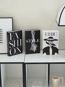Modern black and white decorative fashion books set on white storage shelf, detailed close-up.