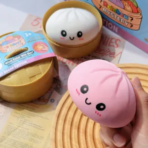 Gros plan d'un jouet spongieux en forme de brioche à la vapeur rose avec une face mignonne
