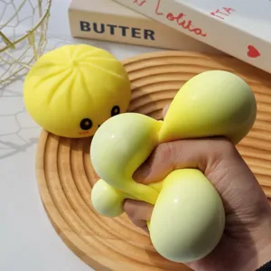 Gros plan d'un jouet anti-stress en forme de baozi jaune pressé pour se détendre