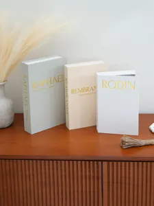 Detailed view of decorative fake book storage boxes with linen texture and gold stamping.