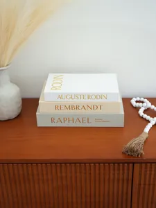 Close-up detail of decorative storage books with linen texture and elegant gold stamping design.