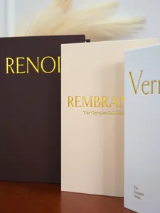 Detail shot of decorative faux book storage boxes with linen texture and gold foil print.