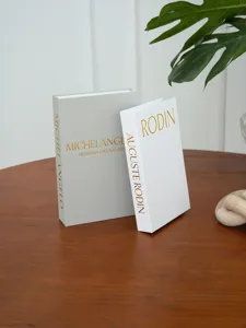 Detail shot of linen decorative faux books with gold stamping, elegant coffee table decor.