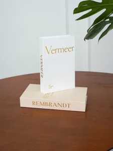 Linen texture decorative fake book detail, gold foil stamping, coffee table styling.