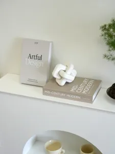 Decorative English fake books set with modern sculptural knot for coffee table and home decor detail.