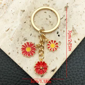 Portachiavi in metallo dorato con ciondoli a margherita in smalto rosso e giallo.