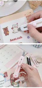 Primer plano de mini cúter con diseño de zarpa de gato, papelería compacta para manualidades.