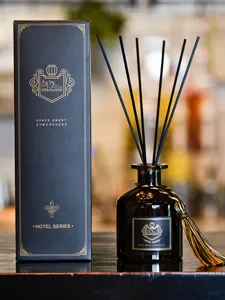 Coffret de parfum d'ambiance noir avec emballage doré pour une maison élégante.