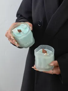 Detail view of frosted crystal scented candle with wooden wick and aesthetic blue wax.