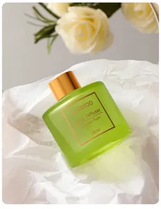 Primo piano dettaglio del flacone diffusore in vetro smerigliato verde con tappo dorato.