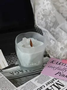 Detail shot of frosted glass scented candle with crystal stones and wooden wick.