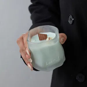 Frosted glass jar scented candle with wooden wick and light green wax for home decor