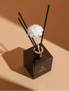 Glass bottle reed diffuser set with black sticks and white flower for home fragrance