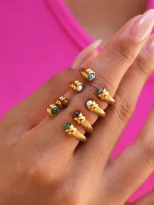 Detailed view of stackable twisted cable rings with natural stones in gold finish for women.