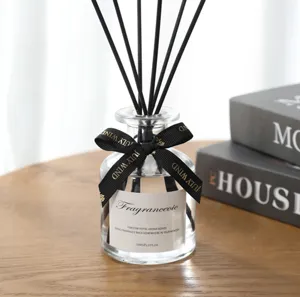 Reed diffuser glass bottle with black sticks and ribbon for indoor home fragrance decoration.