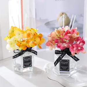 Diffusore di profumo senza fiamma con fiori di ortensia artificiali e flacone in vetro.