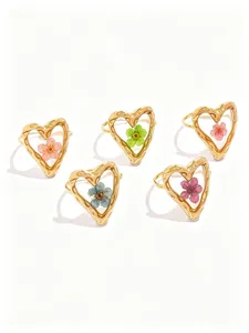 Detailed view of trendy stainless steel heart rings with colorful dried flower designs for women.