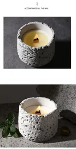 Detailaufnahme der Duftkerze mit Beton Textur, Holzdocht und warmem Licht für schöne Dekoration.