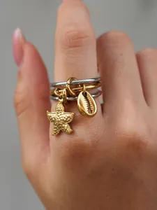 Nahaufnahme des mehrlagigen Edelstahlrings mit charmanten Seestern- und Muschelanhängern.