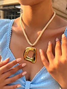 Detailopname van een trendy chunky gouden vierkante hangerketen met dik touwketting.