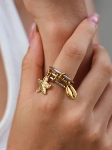 Nahaufnahme des Edelstahl Rings mit niedlichen Seestern und Muschel Anhängern im Detail.