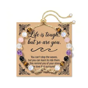 Detail view of adjustable natural stone bead bracelet with a metal wave charm on card.
