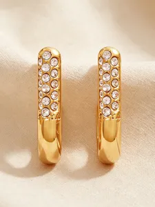 Detail view of stylish gold J-shape hoop earrings sparkling with inlaid crystals.