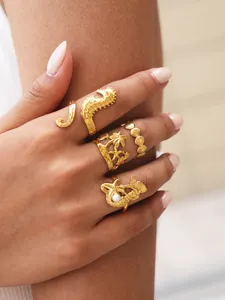 Nahaufnahme stilvoller goldener Meeresringe mit Seepferdchen, Muschel und Palmenmotiv.