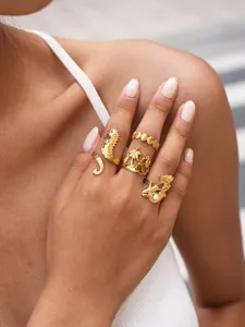 Goldfarbenes Edelstahlozean-Themen-Ring-Set Detail mit Seepferdchen und Muscheln.