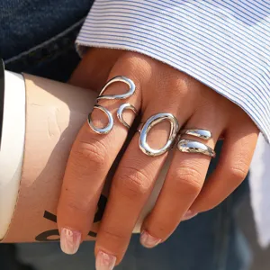 Primer plano detallado del conjunto de anillos de plata geométricos, estilo minimalista moderno.